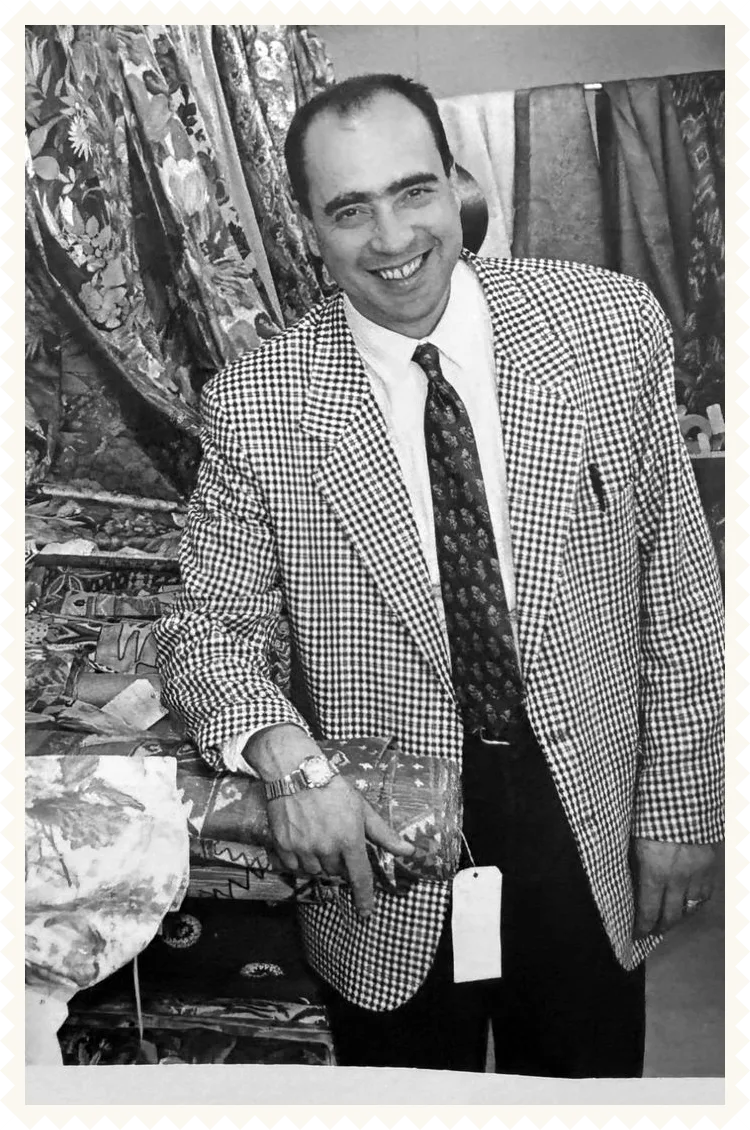 Photo d’archive en noir et blanc : souriant, au milieu des rouleaux de tissus du magasin Papin Tissus