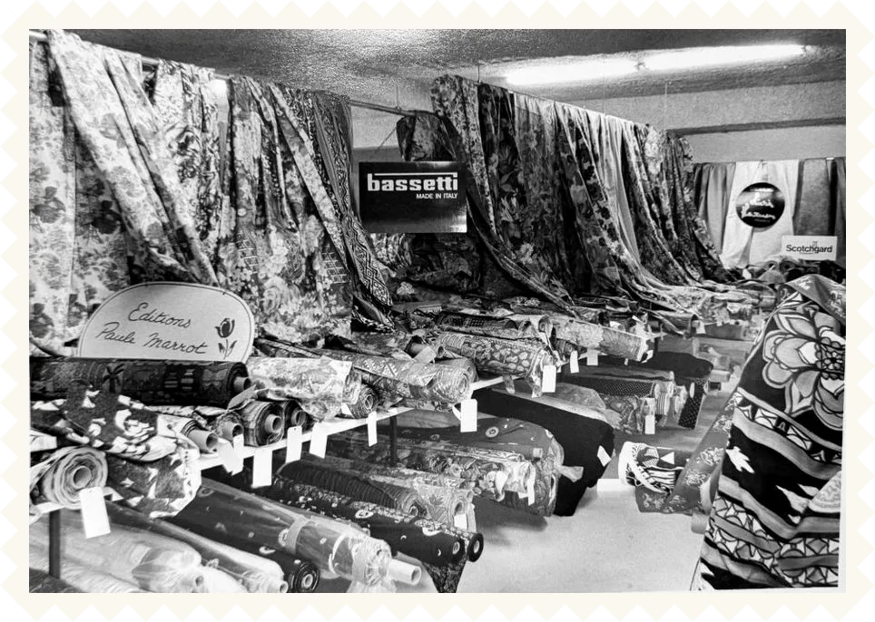 Photo d’archive en noir et blanc : le magasin Papin Tissus, rouleaux et tentures de tissus imprimés